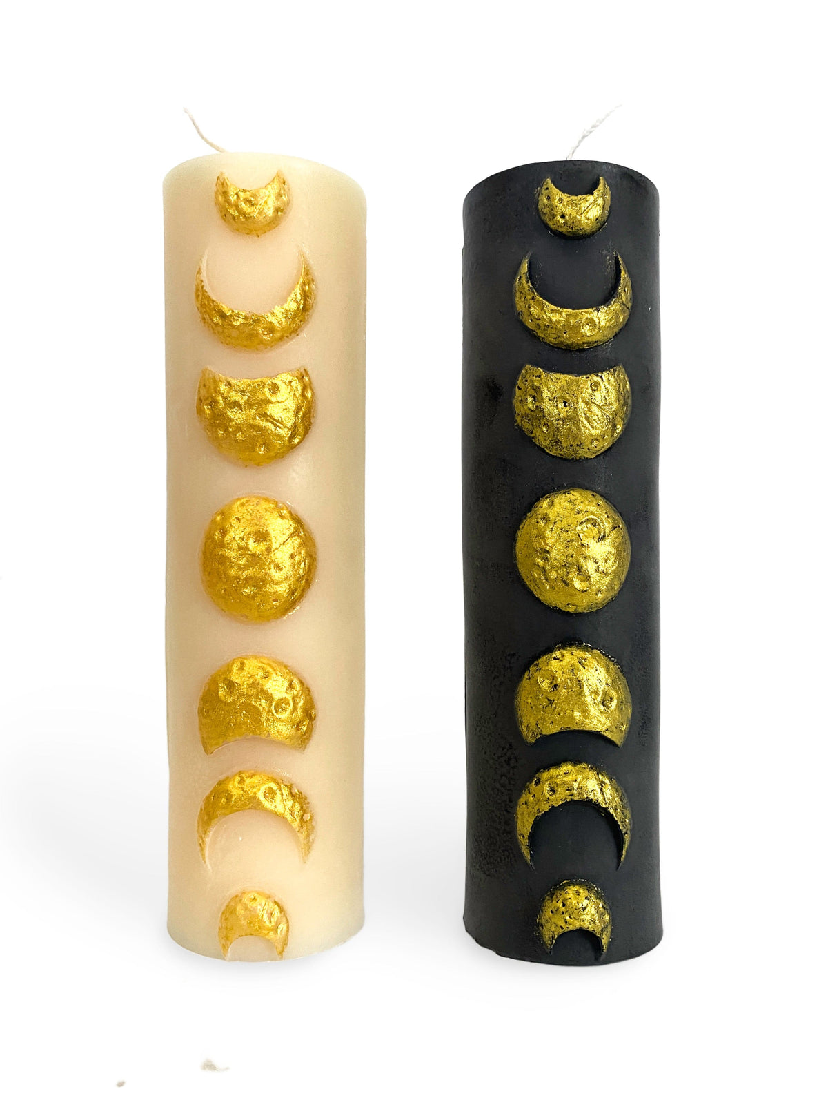 A Pleasant Thought’s Golden Moon Phase Pillar Candles—one white, one black—are crafted from soy wax and elegantly embossed with metallic gold crescent-to-full moon phases in a celestial design.