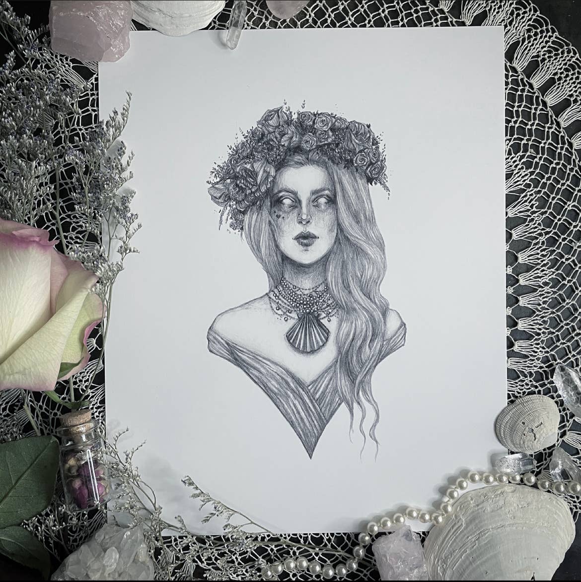 The Aphrodite 10 x 8 Fine Art Print by Caitlin McCarthy Art features a black and white drawing of the Greek Goddess with long hair, floral crown, and dark eye makeup—ideal for display on archival matte paper.