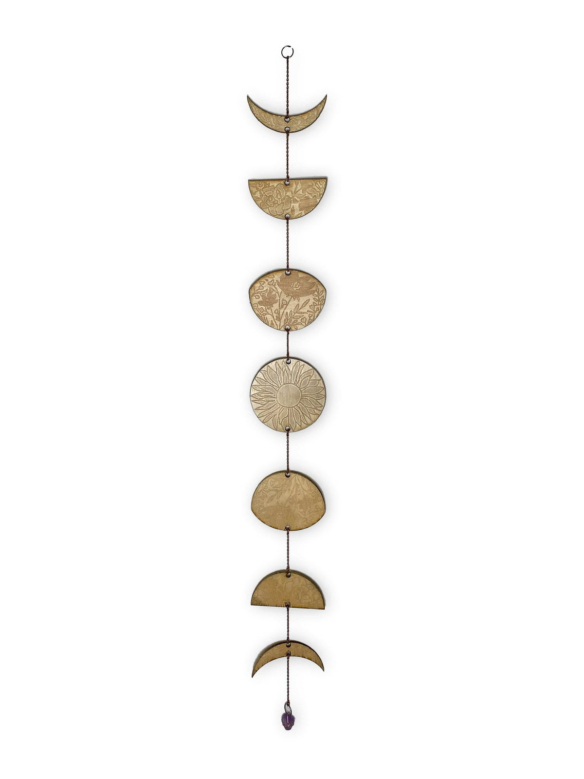 The Gold Floral Phases of the Moon Garland with Amethyst by CSAcreative features intricately engraved moon phases linked vertically, adorned with floral designs and finished with an amethyst charm at the bottom.