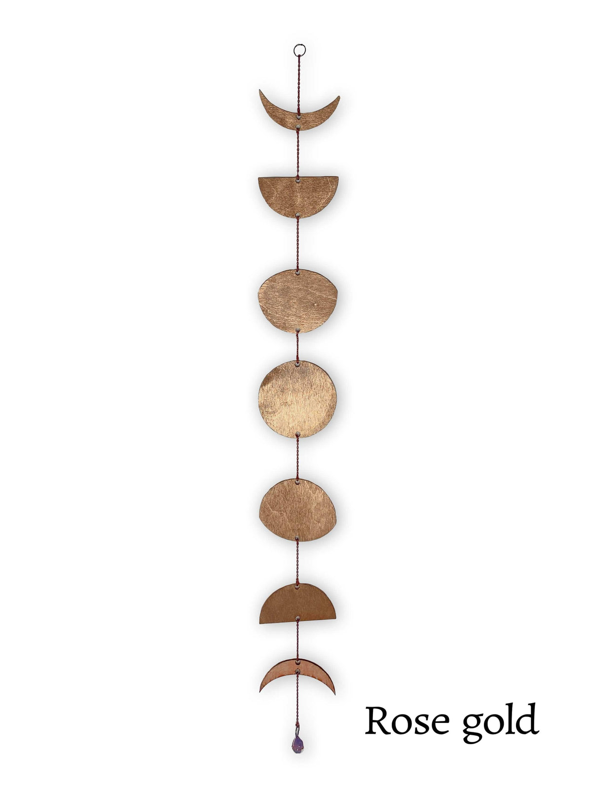 The CSAcreative Gold Floral Phases of the Moon Garland features seven gold metal shapes hung vertically, each representing a moon phase, with an amethyst bead at the bottom and Gold text in the lower right corner.
