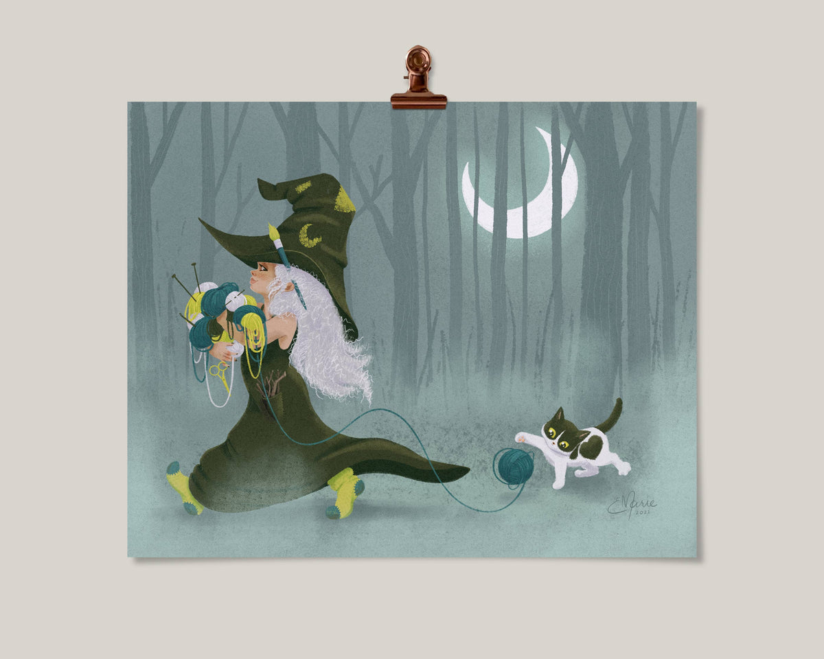 The Witch Crafts Art Print (8 x 10) by Elissa Marie Creative features a white-haired witch with a green hat carrying yarn, while a black and white cat chases a ball—a cozy crafternoon scene set in a misty, moonlit forest.
