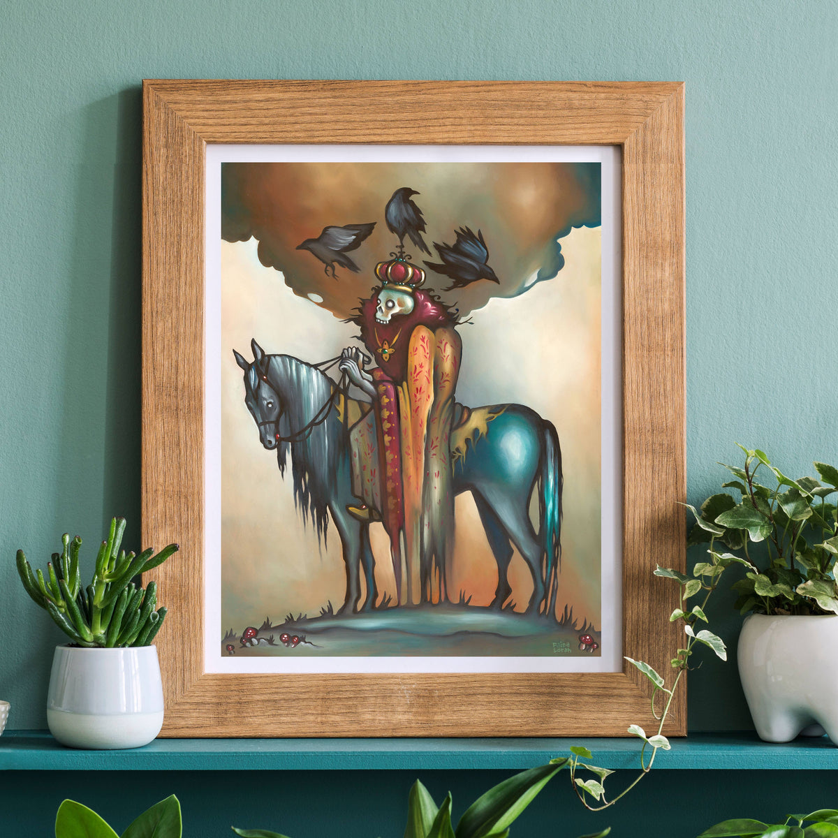 The *Retiring* Deathless King Slavic Art Print by Faina Lorah, 14 x 11, shows Koschei the Deathless masked and crowned in red atop a blue horse with crows. Displayed above potted plants, it hangs on a green wall.