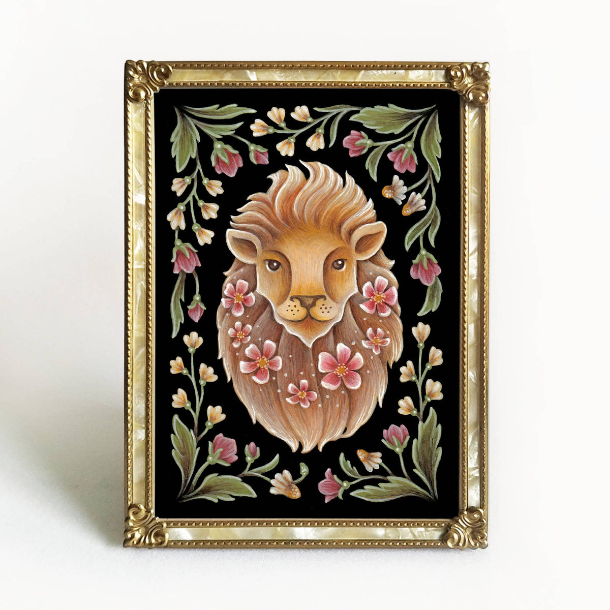 The *Retiring* Lion Folk Art Print by Faina Lorah features a soft-maned lion with pink flowers and green leaves on black, in an ornate gold-toned frame that enhances the delicate watercolor. Available in multiple sizes.