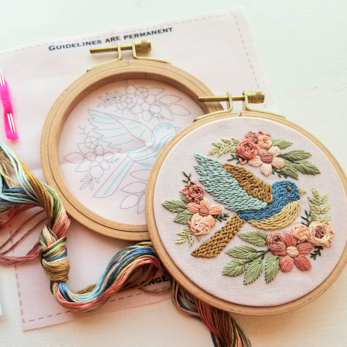 The 4 Beginner Bluebird Sampler Embroidery Kit by Jessica Long Embroidery features a vibrant stitched bluebird with floral accents, a matching paper pattern, and thread—ideal for beginners or as an inspiring embroidery sampler.