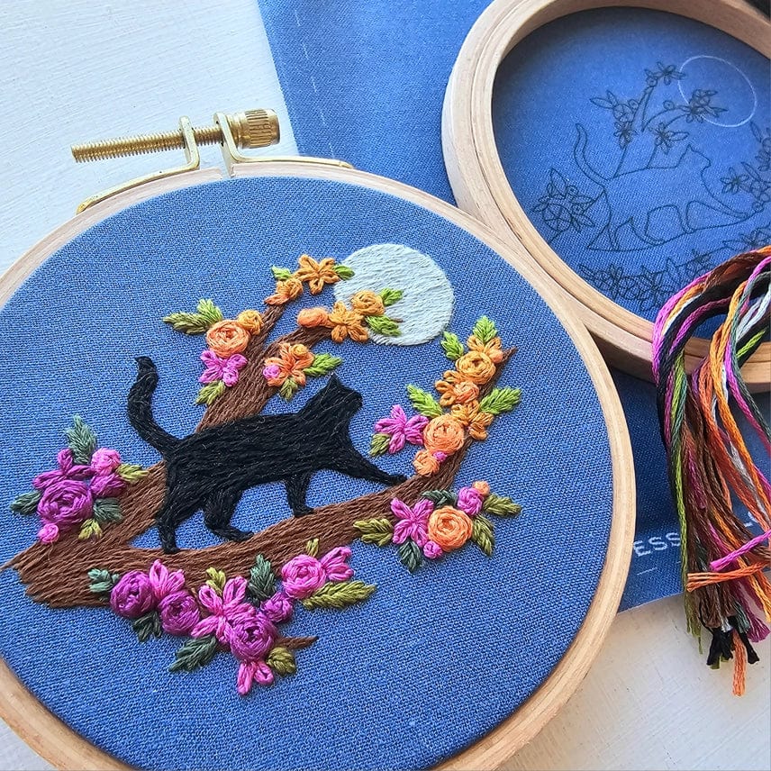 The 4 Beginner Mini Black Cats & Full Moon Embroidery Kit by Jessica Long Embroidery features a black cat on a tree branch with colorful flowers and a moon—perfect for beginners or as a charming mini kit.
