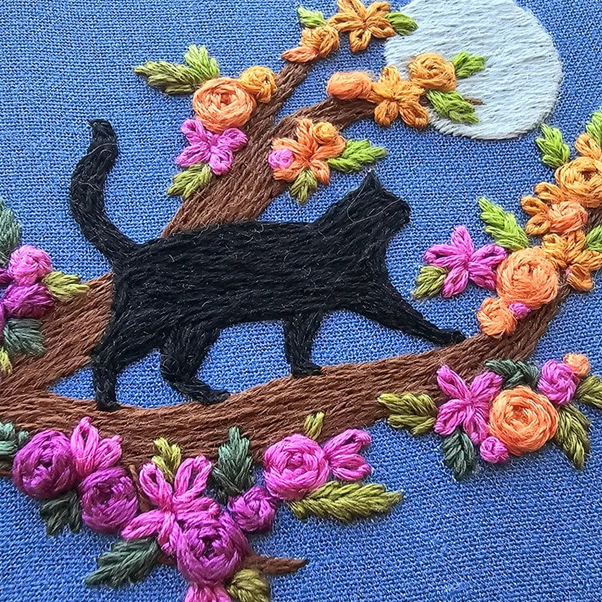 The 4 Beginner Mini Black Cats & Full Moon Embroidery Kit by Jessica Long Embroidery features a black cat on a tree branch with colorful flowers, leaves, and a full moon—ideal for beginners.