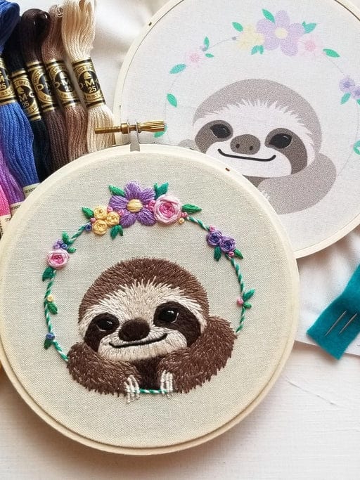 The 5 Beginner Smiling Sloth Embroidery Kit by Jessica Long Embroidery features a cheerful sloth surrounded by flowers—ideal for DIY gifts or adding to your crafting kit.