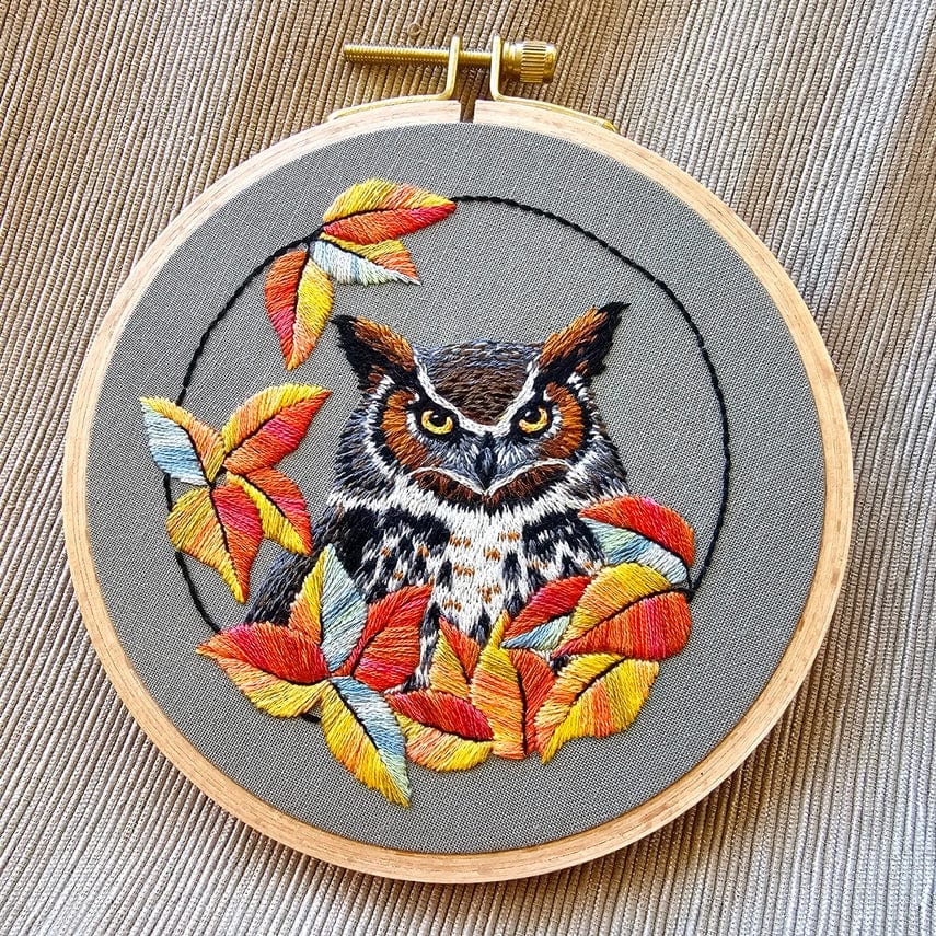 The *Late May Pre-Order* 5 Great Horned Owl Embroidery Kit by Jessica Long Embroidery features an embroidered owl with detailed feathers among autumn leaves in a wooden hoop—perfect for practicing thread painting.