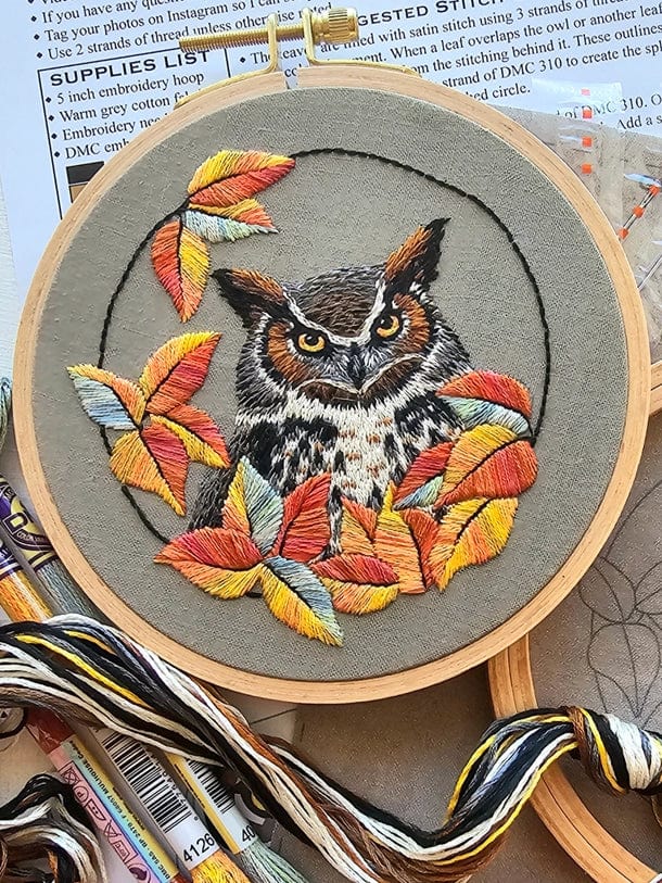 The *Late May Pre-Order* 5 Great Horned Owl Embroidery Kit by Jessica Long Embroidery features a detailed owl amid autumn leaves in orange, yellow, red, and brown thread painting; includes floss and pattern instructions.