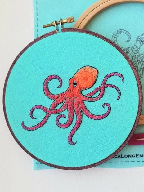 The 5 Beginner Pacific Octopus Embroidery Kit by Jessica Long Embroidery features a detailed orange and pink octopus on turquoise fabric—an ideal ocean-inspired wall art piece for sea life lovers.