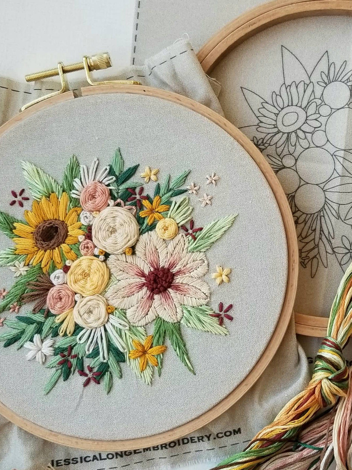 The 6 Beginner Floral Harvest Embroidery Kit by Jessica Long Embroidery features a vibrant sunflower and floral design, fabric pattern outline, and multicolored floss. The website jessicalongembroidery.com appears in the background.