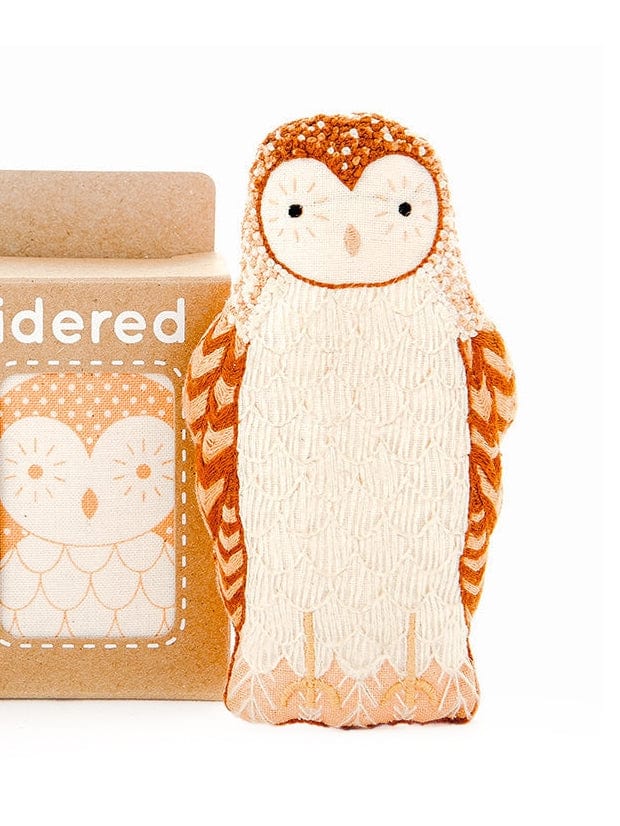 The Barn Owl Embroidery Doll Kit by Kiriki Press features a plush owl toy with white and orange accents beside a matching illustrated brown box—an ideal embroidery doll kit for creative beginners.