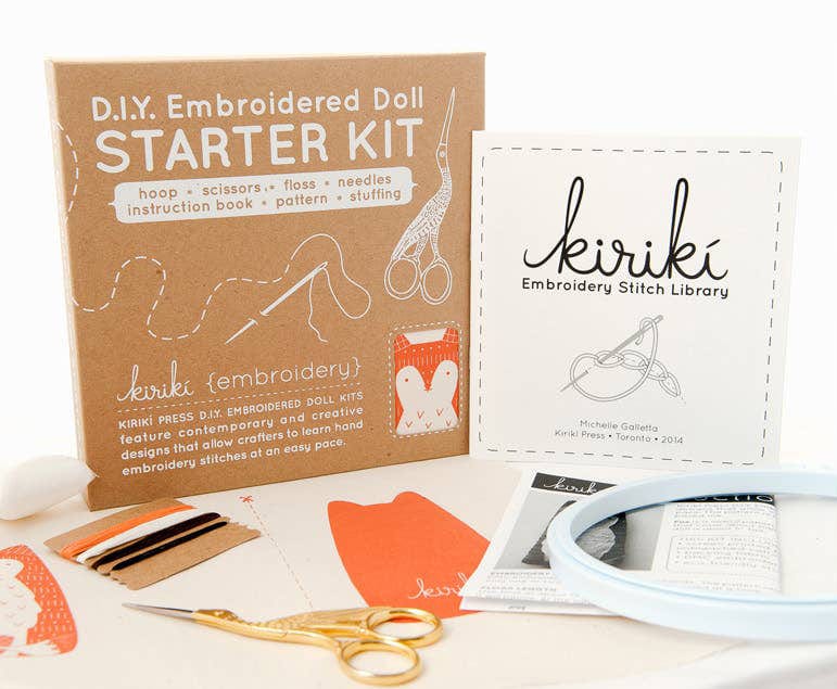 The Kiriki Press Hedgehog Embroidery Doll Kit includes a brown box, stitch guide, scissors, thread, needle, felt pieces, pattern, hoop, and stuffing—everything to craft your own embroidered hedgehog doll.