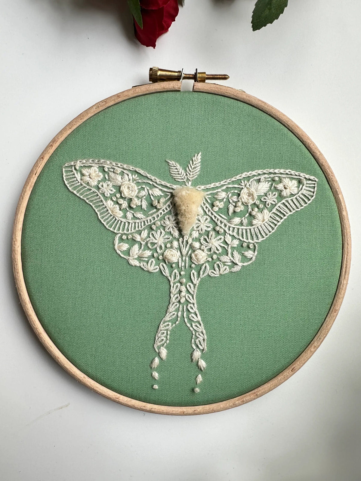 The Nest Embirdery *Late May pre-order* 6 Beginner Vintage Moth Embroidery Kit features a white lace moth on green fabric with intricate, antique-inspired floral patterns and 3D textures on its wings and body.