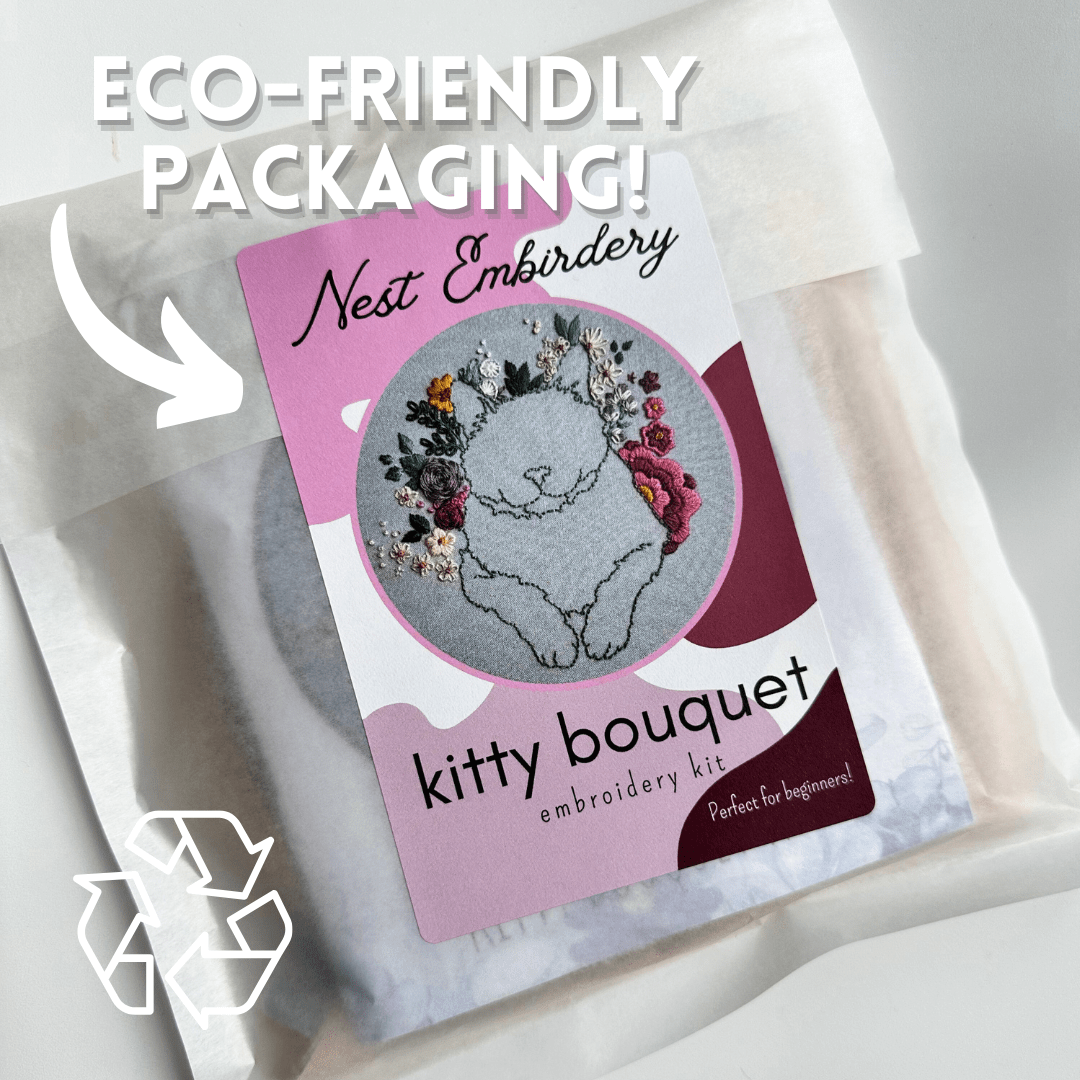 The 6 Beginner Kitty Bouquet Kit by Nest Embirdery comes in eco-friendly packaging, features a charming cat with flowers, recycled symbol, and ECO-FRIENDLY PACKAGING! text—perfect for cat-lovers and advanced beginner stitchers.