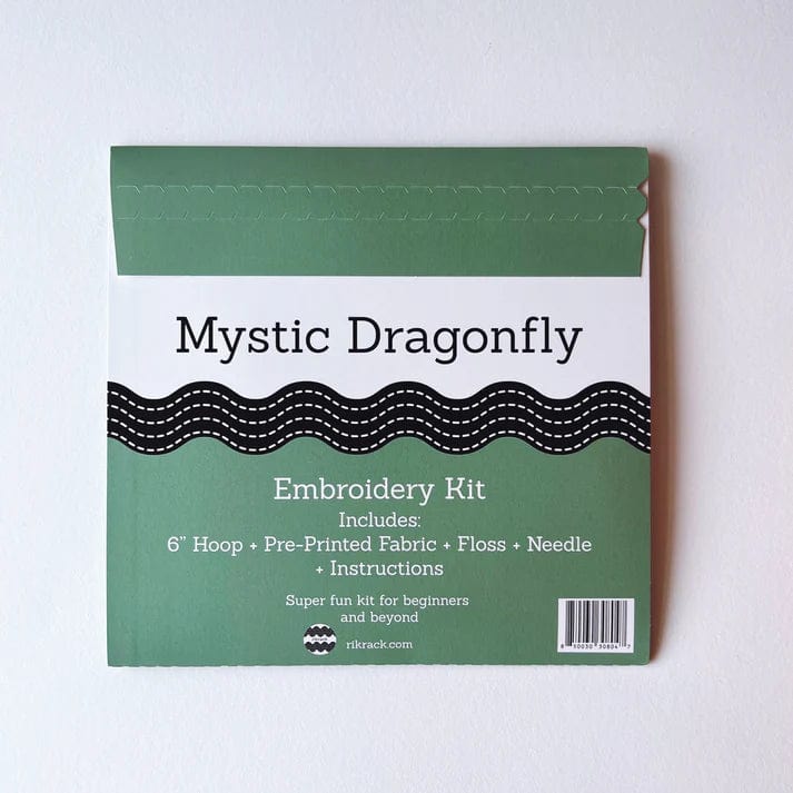 The Rikrack 6 Beginner Mystic Dragonfly Embroidery Kit includes a hoop, pre-printed fabric, floss, needle, and instructions. Perfect for beginners, this green-and-white package makes embroidery easy and fun for all skill levels.