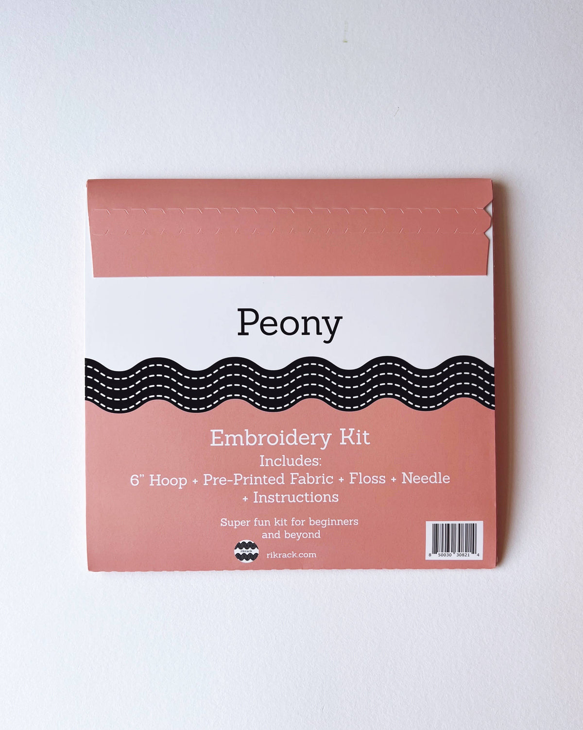 The Rikrack 6 Beginner Peony Embroidery Kit includes a hoop, pre-printed fabric, floss, needle, instructions, and embroidery tips—perfect for beginners with its pink and white peony design.