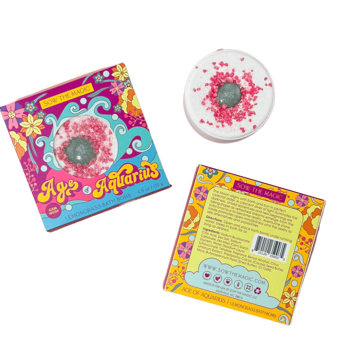 The Sow the Magic Age of Aquarius Lemongrass Bath Bomb with Aventurine features pink and white tones and comes in vibrant floral packaging with product details on the back, evoking a sense of spiritual healing.
