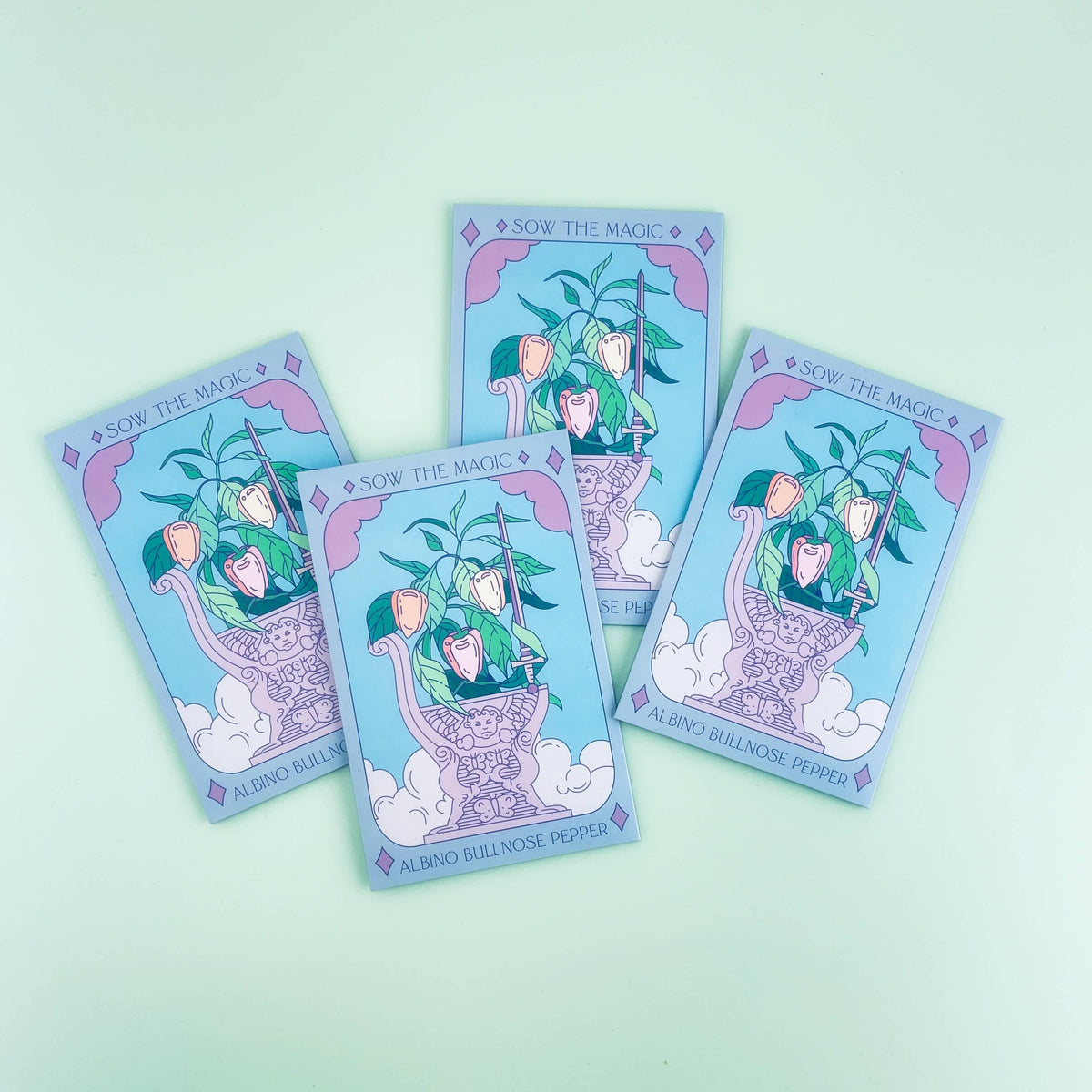 Four Sow the Magic Albino Bullnose Pepper Tarot Garden Seed Packets are arranged on a light green background, each showing peppers in decorative pots with whimsical tarot card-inspired art.