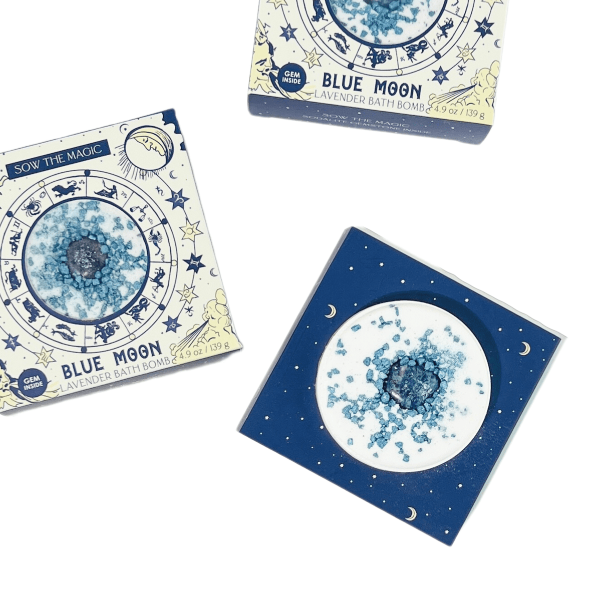 Three boxes of Sow the Magics Blue Moon Lavender Bath Bomb with Sodalite are shown on a white background, two closed and one open to reveal the blue crystal-infused bath bomb in lunar-inspired packaging.