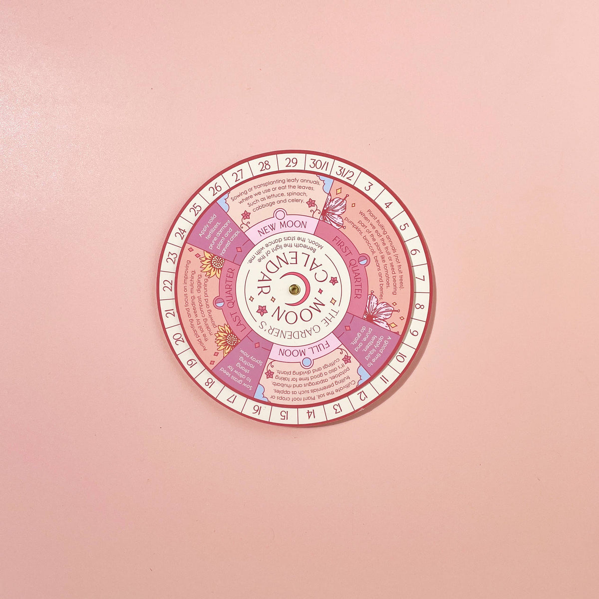 The Moon Phase Calendar Spinner Planting Guide by Sow the Magic features dates, moon phases, and pastel gardening tips on a pink background with floral illustrations to help you garden by the moon phases.