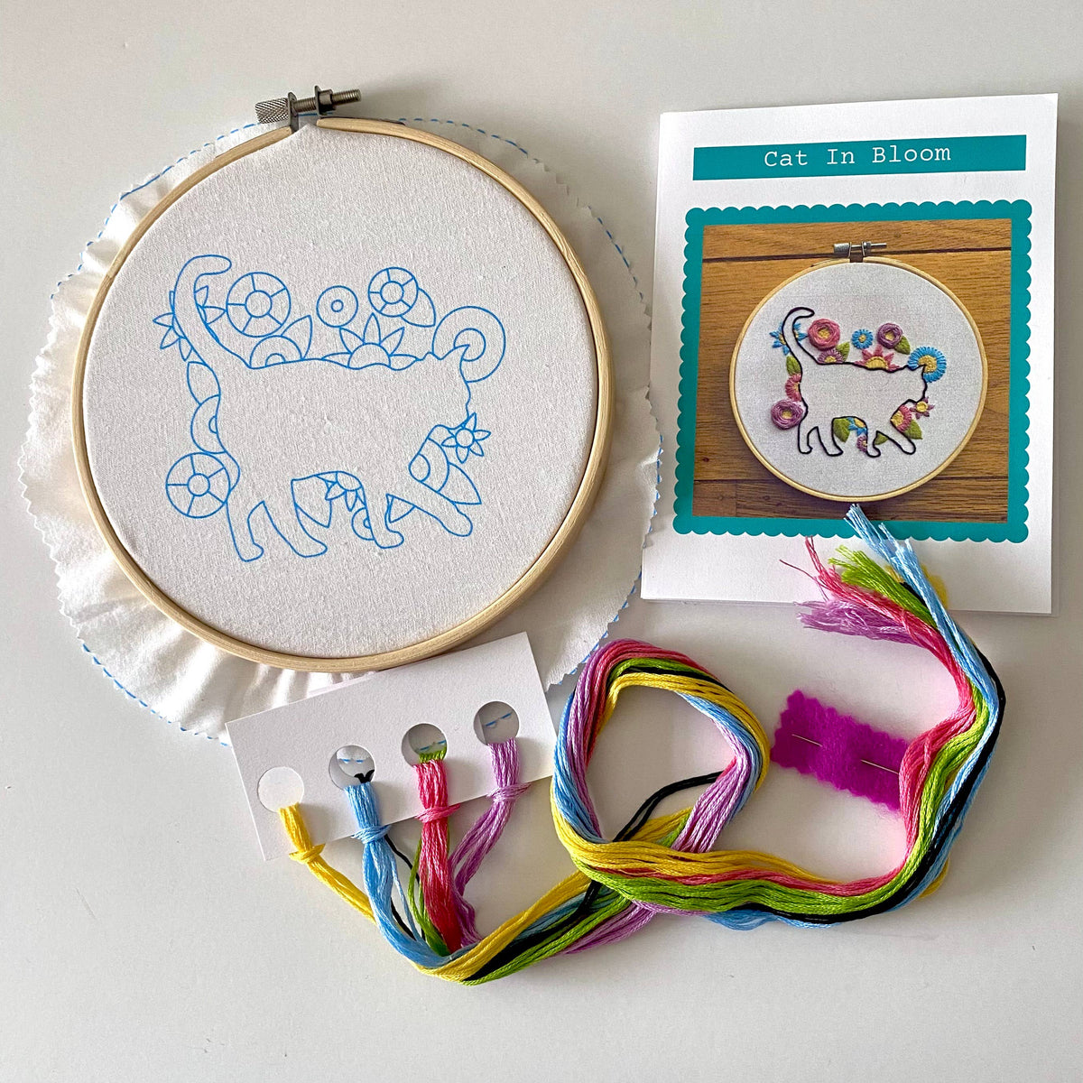 The 6 Beginner Cat in Bloom Silhouette Sampler Embroidery Kit by Stitches By Tiff includes a hoop, floral cat outline on fabric, colorful floss, and instructions—ideal for DIY art lovers or fans of sampler patterns.