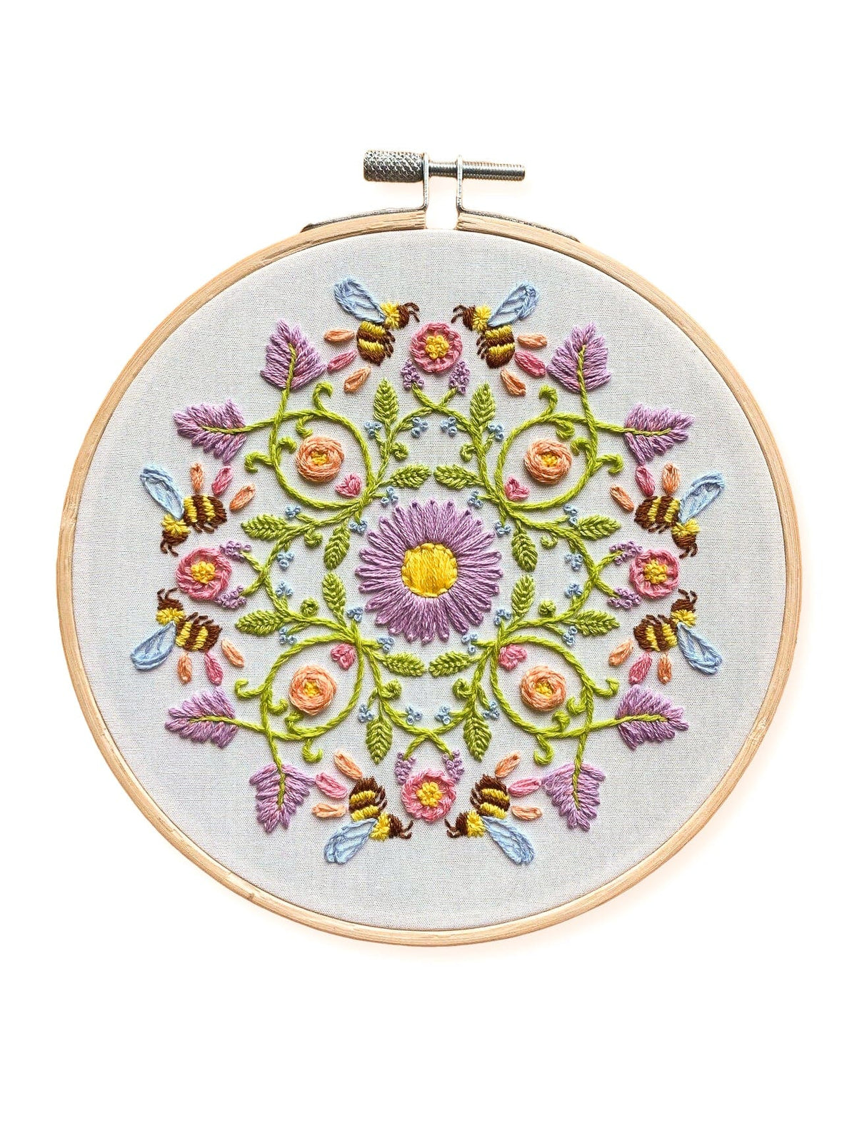 The Stitches By Tiff 6 Bee Mandala DIY Embroidery Kit features a round hoop with a colorful floral pattern, including purple, yellow, and pink flowers, green leaves, and bees on white fabric—perfect for beginner art projects.