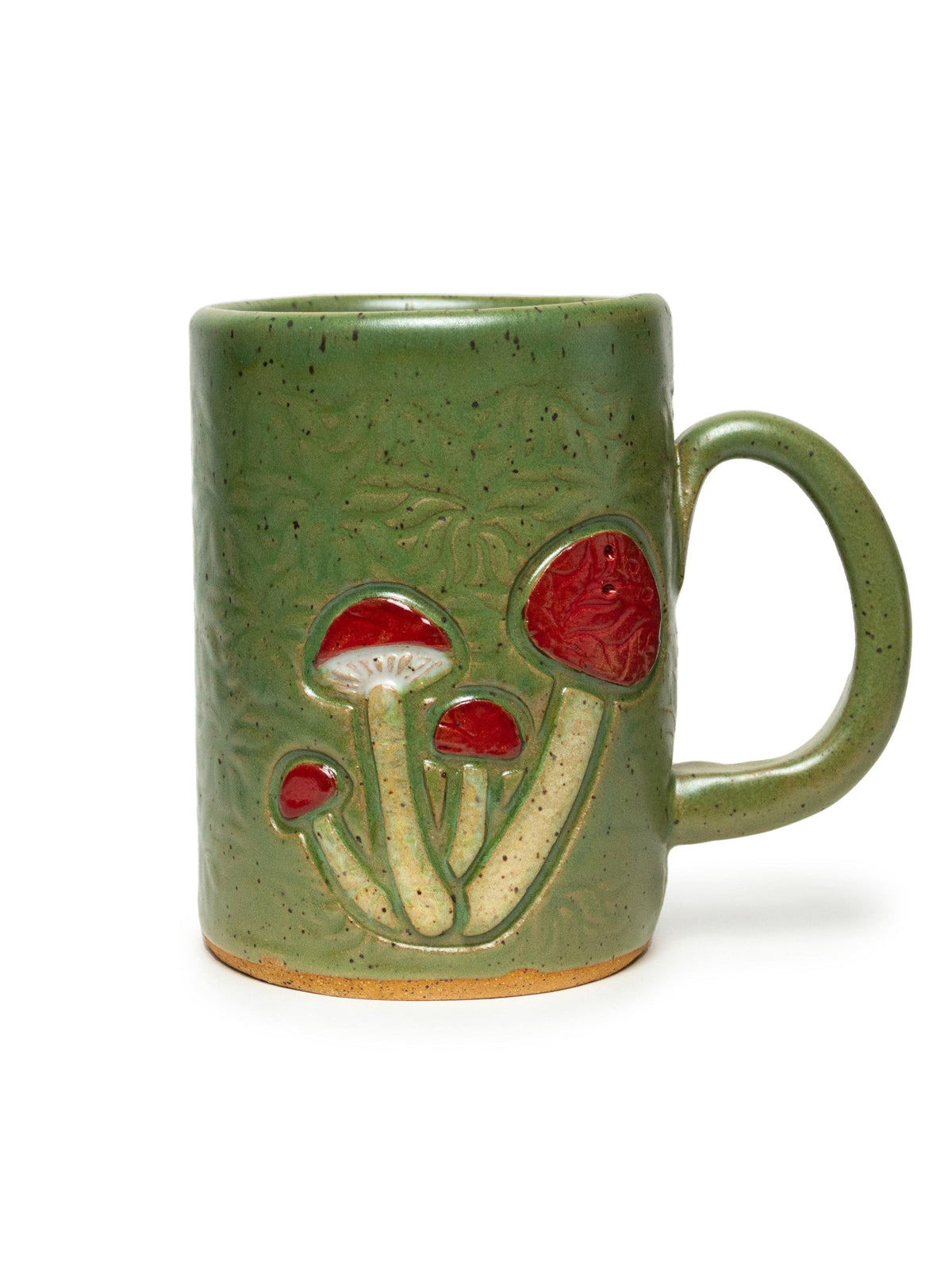 The Mushroom Design Handmade Ceramic Mug, Green 16oz by White Squirrel Clayworks features a rustic, artisanal look with three red and white mushroom designs and a large handle.